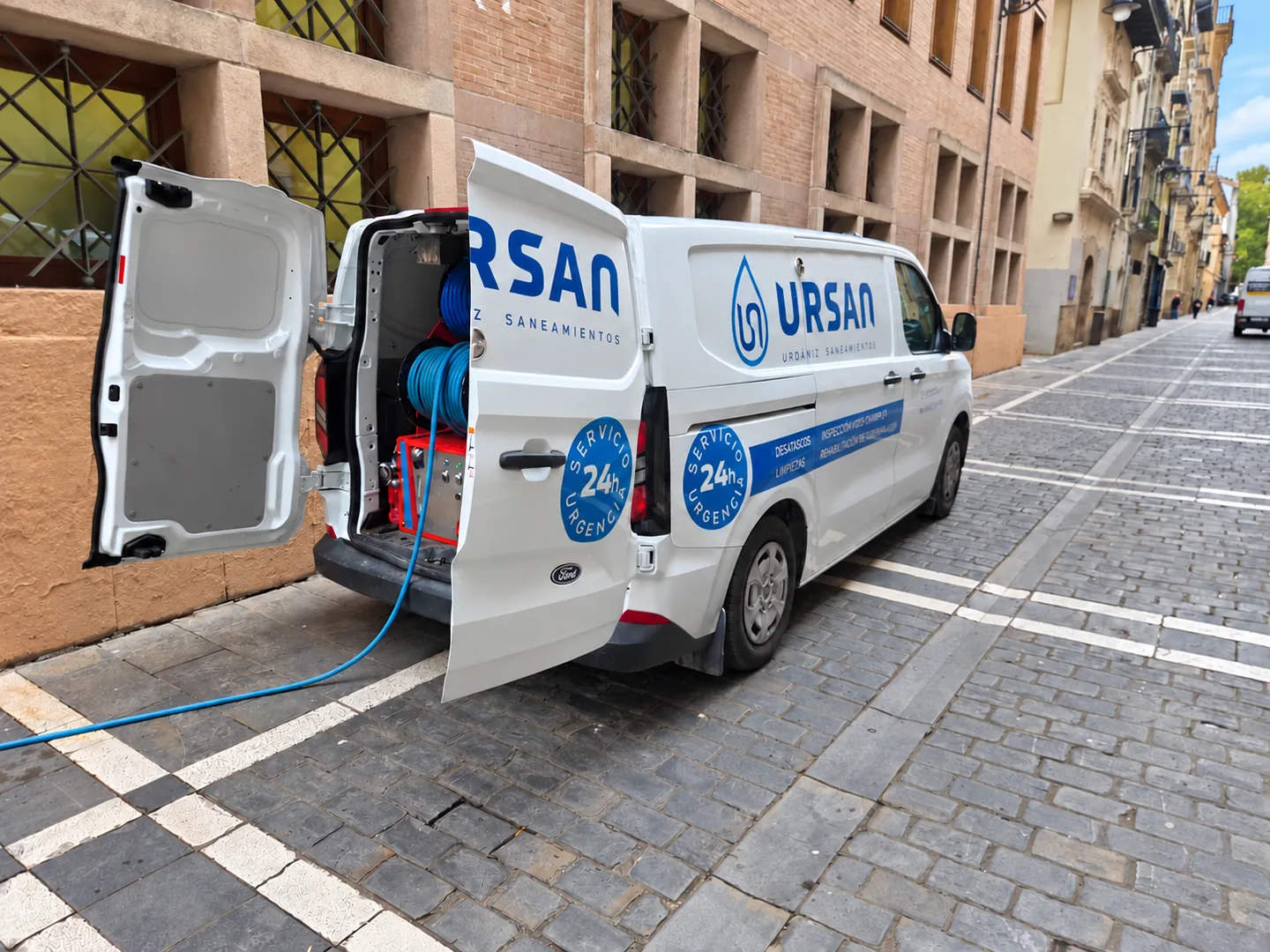 Furgoneta de URSAN con las puertas traseras abiertas y mangueras en su interior.